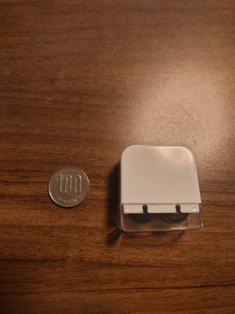 100円玉と並べて比較したダイソー個人情報保護スタンプ黒ダブルローラータイプのサイズ感写真。